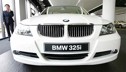A woman uses her mobile phone in a BMW showroom in Beijing