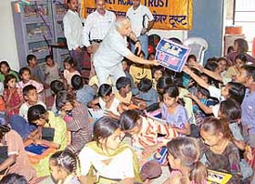 Mr Yash Paul Mahajan, president of the local BJP unit, distributes school bags among the slum children in Sector 25, Chandigarh