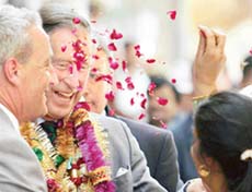 Prince Charles (second from left) is welcomed by a resident with rose petals during a visit to the walled city of Jaipur on Friday. 