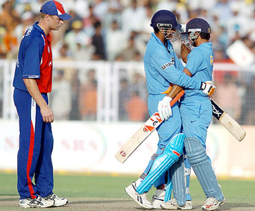 Irfan Pathan and Suresh Raina celebrate Indias victory as England captain Andrew Flintoff looks on during the second one-dayer at the Nahar Singh Stadium in Faridabad on Friday