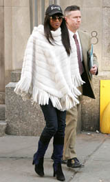 Model Naomi Campbell leaves the Midtown North Precinct with a police officer in New York City