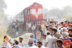 Employees of RCF detain the Jammu-Tawi Express near the factory premises on Saturday in protest against the alleged suicide by an RCF worker in Kapurthala.