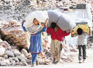 Kashmiri children carry relief supplies in earthquake-hit Muzaffarabad, PoK