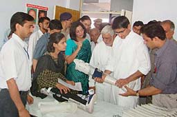Congress MP Deepender Hooda, president, Sewa, presents an artificial limb to a girl at a health camp in Jhajjar on Sunday.