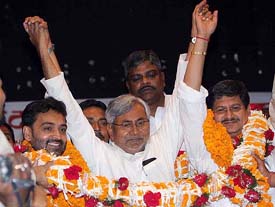 Bihar Chief Minister Nitish Kumar joins hands with newly elected state JD (U) president Rajiv Ranjan Singh (right) and General Secretary Upender Kushwaha  at the party's state council meeting in Patna on Sunday