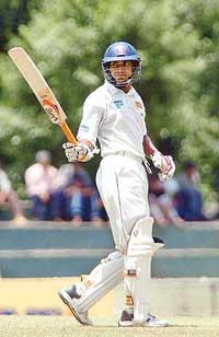 Sri Lankas Kumar Sangakkara raises his bat after scoring a half century on the first day of the second Test match against Pakistan at the Asgiriya cricket ground in Kandy on Monday. 