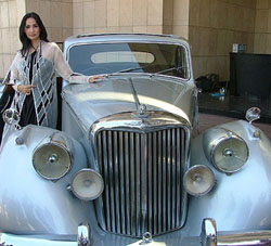 Model Simar Duggal displays a creation by Meera & Muzaffar Ali, alongside a Jaguar car, on the eve of the Wills Lifestyle Indian Fashion Week in New Delhi 