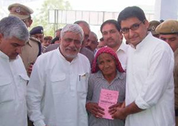 Dr Raghubir Singh Kadian, Speaker of the Haryana Assembly, and Mr Deepender Hooda, MP, hand over a health card to a patient at a health camp in Jhajjar on Tuesday.