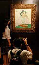 A girl looks at a painting by Vincent Van Gogh LArlesienne, Madame Ginoux estimated to cost between $40-50 million in Hong Kong on Tuesday
