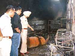Police officials inspect the site where fire broke out at Dugri in Ludhiana on Thursday