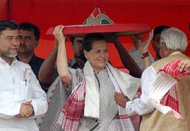 Congress President Sonia Gandhi is presented with a traditional Assamese Japi (hat) by supporters at an election campaign rally in Nagaon, 120 km from Guwahati, on Thursday