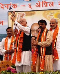 BJP leader LK Advani holds a bow and arrow as he poses with local BJP leaders, including Gujarat Chief Minister Narendra Modi (right), in Rajkot