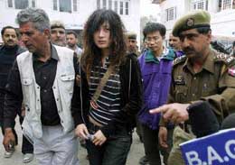 Liu Tsai Lin, daughter of Huang Sui Chin, escorted by a police official, after she identified the body of her mother in a police morgue in Srinagar on Saturday.