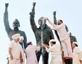 Statutes of martyrs Bhagat Singh, Sukhdev and Rajguru get a bath from Congress Seva Dal volunteers in Ludhiana on Saturday. 