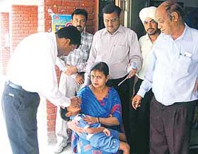 Dr K.C Goel, DHO, Sangrur, administers polio drops to a child at the Civil Hospital in Ahmedgarh