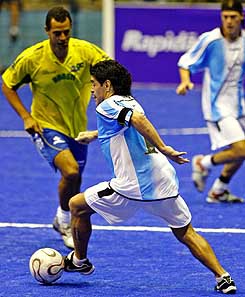 Argentinean soccer legend Diego Maradona dribbles past Brazil's Alexandre Torres during a Showball exhibition game between Argentina and Brazil