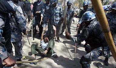 Nepali armed police beat up a pro-democracy demonstrator at Goagabu in Kathmandu as protesters shout anti-monarch slogans