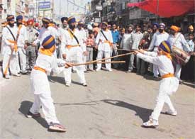 Two children display gatka skills during a nagar kirtan on the eve of Baisakhi in Ludhiana on Thursday
