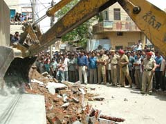 Demolition squad of the Municipal Corporation brings down an illegal structure in the Bhargo Camp area