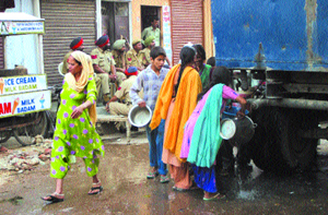 Residents of the Bhargo Camp area in Jalandhar collect water from a tanker sent by the Municipal Corporation on Sunday.