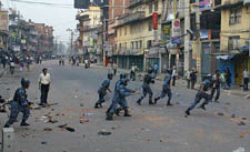 Nepali police run after demonstrators at Chahabahil in Kathmandu on Monday. The troops opened fire on anti-monarchy protesters in an eastern town on Monday and killed one man, witnesses and officials said
