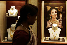 A sales representative walks past jewellery displayed in a shop in Bangalore on Tuesday. 