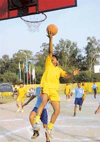 A player of 30 Battalion tries to score a goal against GC, Pinjore, at the Inter Battalion Basket Ball Tournament at CRPF, Hallomajra, in Chandigarh