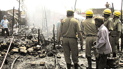 Firemen at the site of a fire in the slum cluster of Yamuna Pushta, which destroyed around 60 shanties on Thursday
