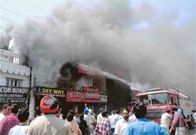 Thick smoke billows out of a shop on the Dugri road where a big fire broke out in Ludhiana on Thursday