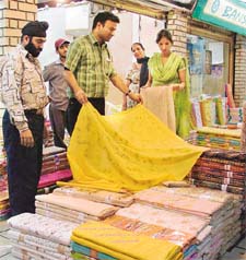 Shopkeepers display a variety of cotton fabric to customers in Ludhiana on Thursday