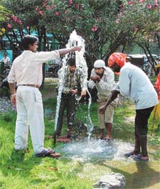 Labourers quench their thirst from a water pipe near Sherpur Chowk as temperatures rise in Ludhiana on Thursday
