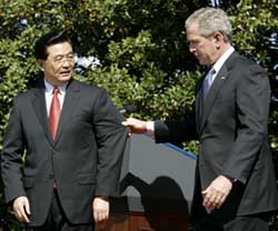 Chinese President Hu Jintao looks back at US President George W. Bush as Bush pulls him back by his suit jacket