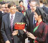 Microsoft Chairman Bill Gates is offered a piece of betel as a traditional greeting by a Vietnamese woman wearing a traditional dress in Vietnam on Saturday.
