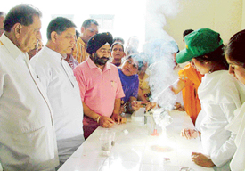 Punjab Education Minister Harnam Dass Johar watches an experiment after inaugurating a science laboratory at Government Girls High School, Madhopuri, on Saturday.