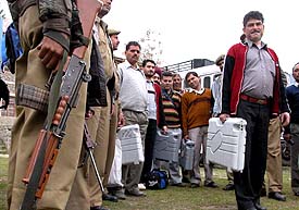 Election officials carry electronic voting machines under tight security on their way to polling stations in Bhaderwah Assembly constituency, about 210 km from Jammu, on Sunday