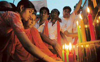 Dalbir Kaur, sister of Sarabjit Singh, and daughter Swapandeep with the activists of the BJP light candles at the Wagah on Saturday evening