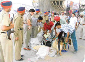 A police team opens a bag under the elevated road that caused panic among shopkeepers near Ghanta Ghar Chowk 