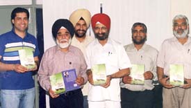 The PAU Director of Extension Education, Dr S. S. Gill, releases a book by Natha Singh Gill in Ludhiana