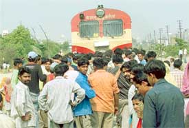 Slum-dwellers stop a train in protest against a demolition drive