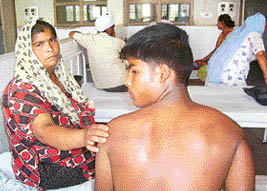 Kamlesh shows injuries sustained by her son Kuljinder Singh who was allegedly tortured by Srinagar police