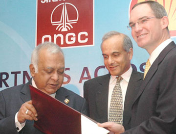 Chairman and Managing Director of the Oil and Natural Gas Corporation Subir Raha and Shell Executive Vice-President, Business Development, Guy Outen hold an agreement document after its signing in New Delhi on Thursday as Chairman of Shell companies in India Vikram Singh Mehta looks on