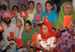Victims of 1984 riots show the red cards, issued to them by the government, during a protest in Jalandhar