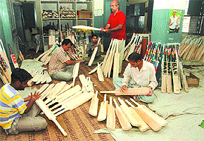 Labourers working to give shape to bats at the Beat All Sports factory in Jalandhar