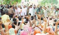 Wing Cdr Paramjit Singh Sibia, Chairman of the Ludhiana Improvement Trust, raises his hand as slum dwellers raise slogans against the demolition drive in Ludhiana on Thursday