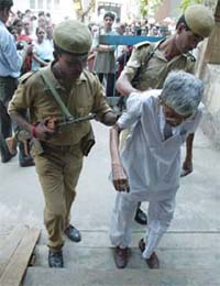 Paramilitary personnel help an elderly voter at a polling station in Kolkata