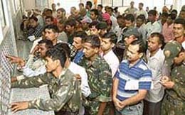 Harassed ticket seekers wait in a queue before the railway reservation counter at the Chandigarh Railway Station as due to a malfunction in the telecommunication link