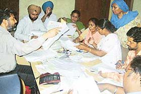 Mr Jatinder Bhola, president, Municipal Council, attends to pension beneficiaries at Town Hall in Mandi Ahmedgarh