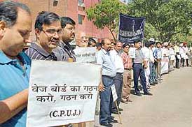 Members of the Chandigarh-Punjab Union of Journalists make a human chain on the occasion of May Day in Sector 17, Chandigarh, on Monday.