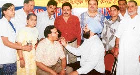 Dr Rajanbir Singh Thind, dental surgeon, examines a patient at a medical camp organised by the Maa Bhagwati Club in Ludhiana