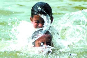 Children splash around in water near India Gate to beat the heat